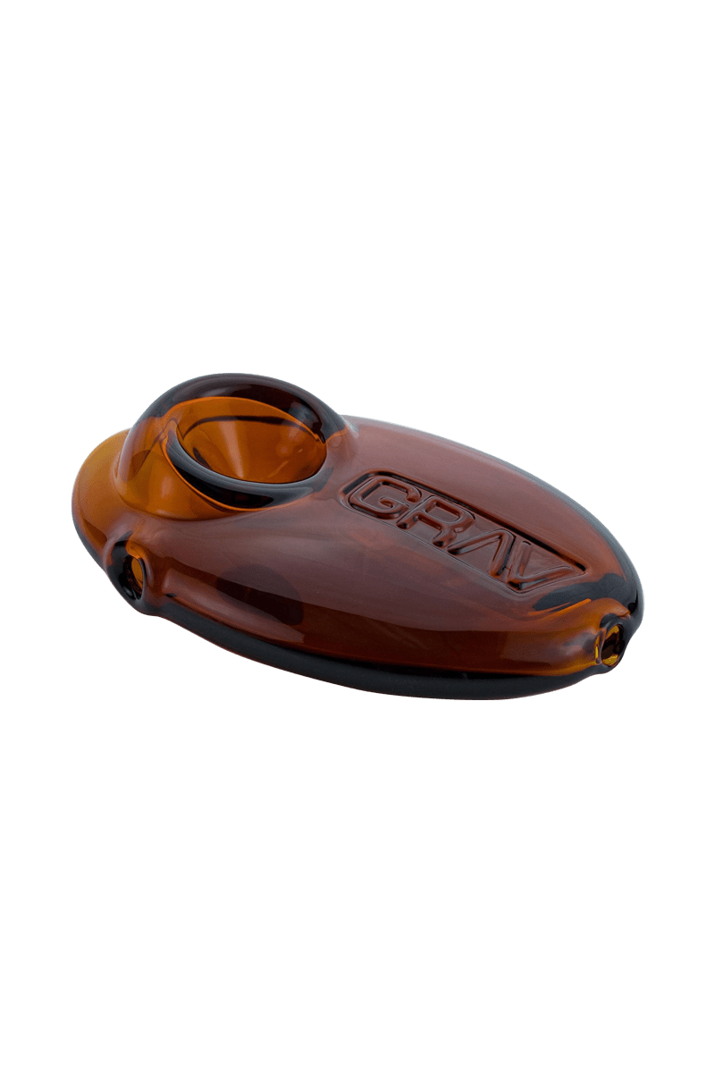 A close-up shot of the Grav Labs Pebble Spoon, showing its smooth, rounded shape and dark amber glass.