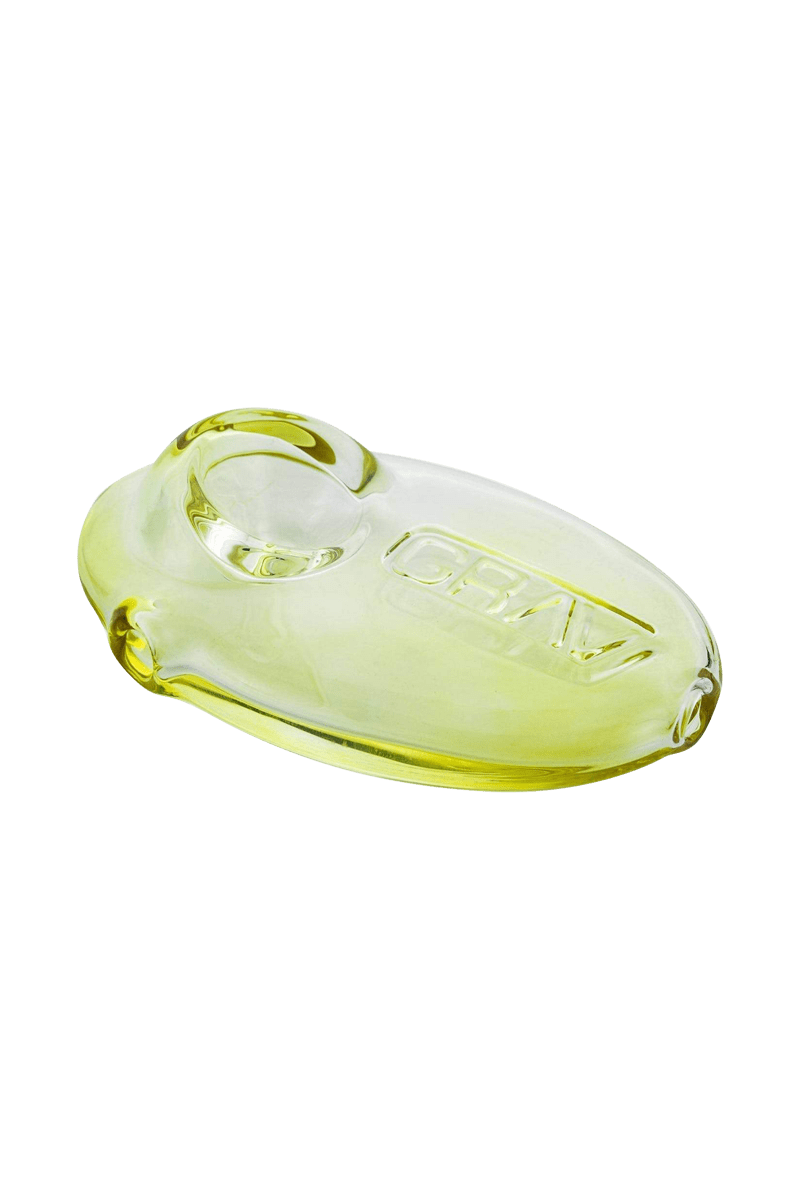 A close-up, angled view of the Grav Labs Pebble Spoon, showing its smooth, rounded glass design.