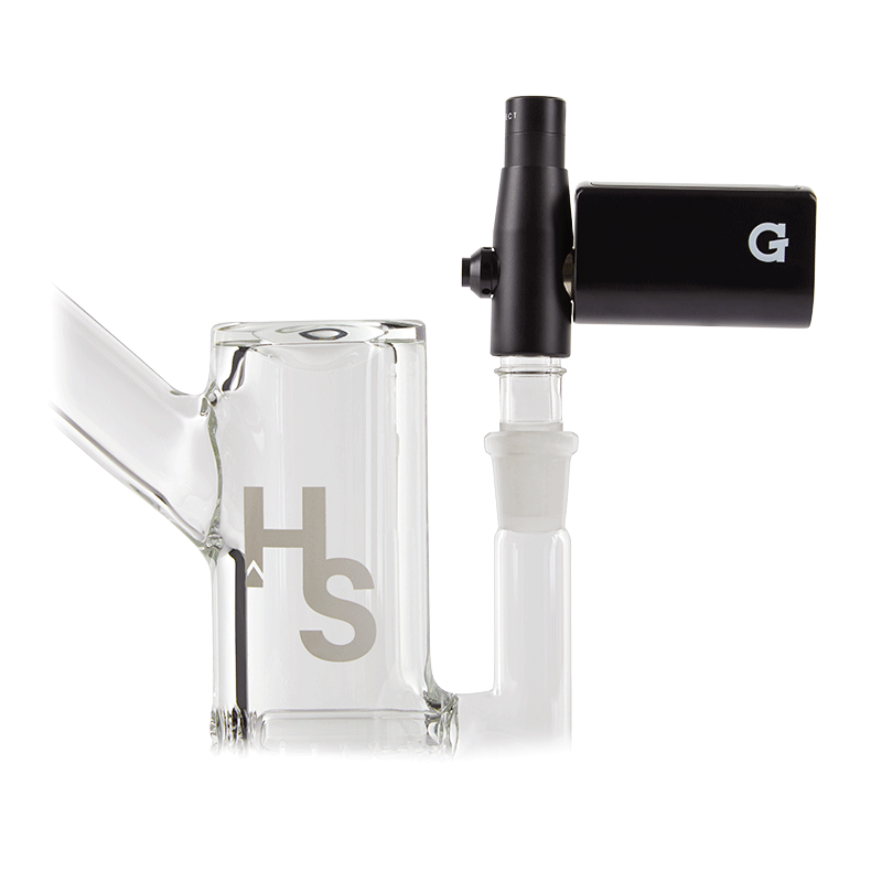 A front view of the G Pen Connect Vaporizer attached to a clear glass beaker, highlighting the device’s sleek, black design.