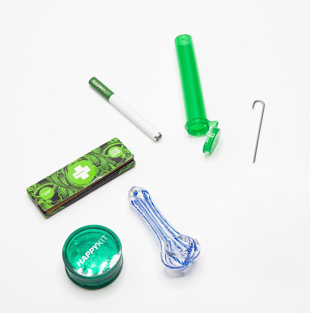 A top-down view of The Happy Kit with a clear glass pipe and a branded, folded paper insert.