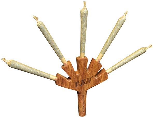 A close-up shows the RAW Level Five Wooden Cig Holder displaying five lit cigarettes arranged like spokes on a wheel.