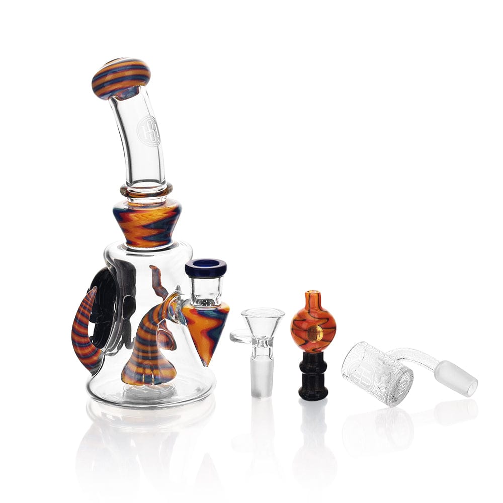 A three-quarter view of the High Society - Tulu Premium Wig Wag Concentrate Rig, featuring blue and yellow glass with detached accessories.