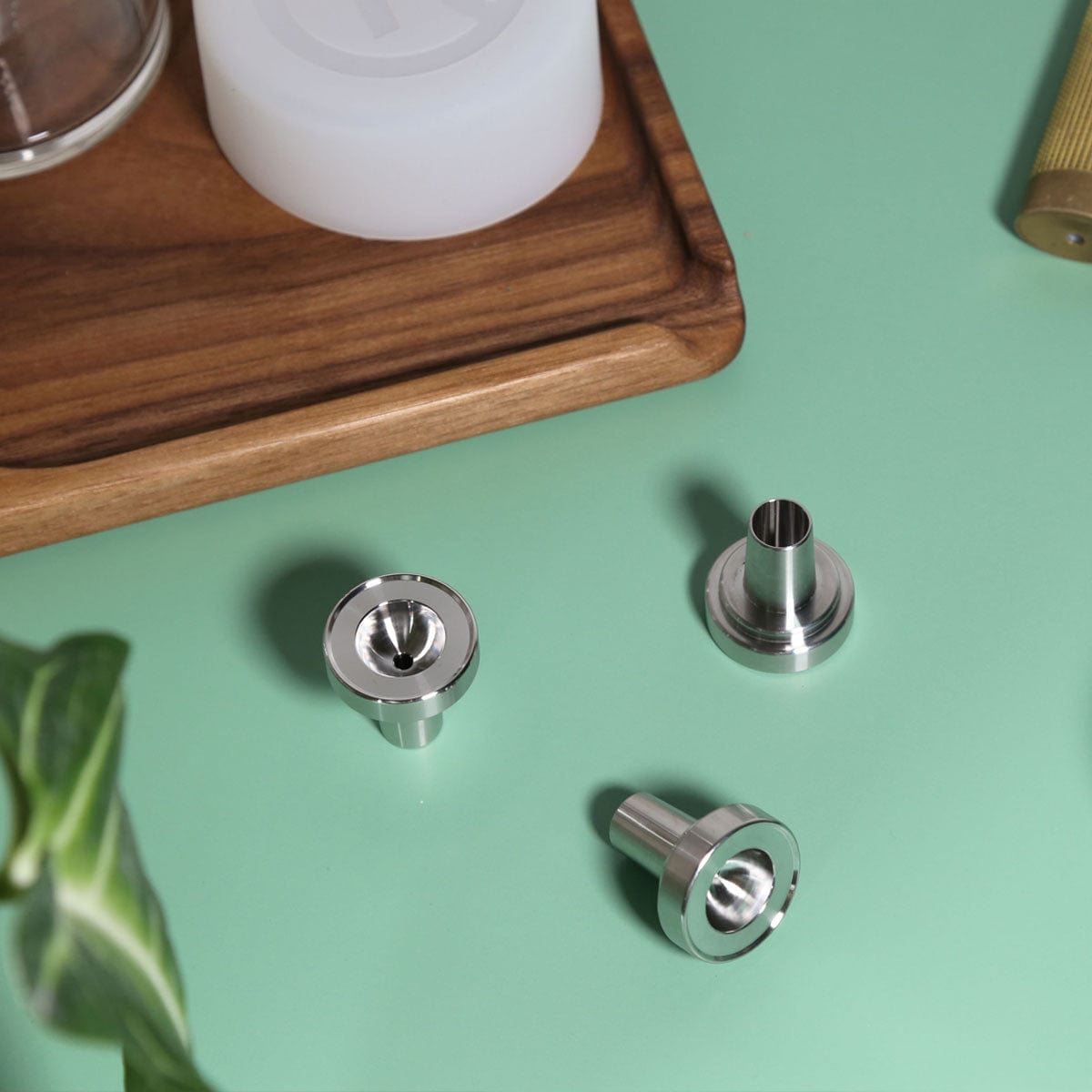 Overhead view of the Stainless Steel Bowl Piece, resting on a dark wooden surface alongside a blurred white object.