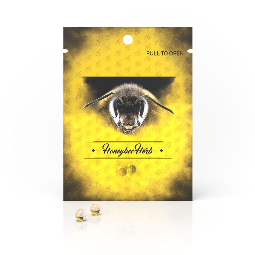 Front view of Honeybee Herb Honey Pearls packaging, showing small, round, gold-colored pearls on a dark background.