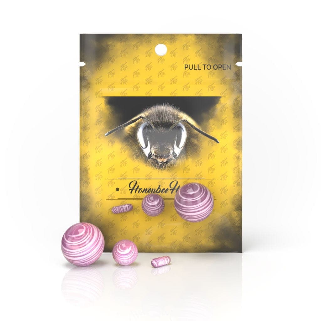 A close-up shot of the Honeybee Herb Dab Marble Set, showcasing the colorful, spherical glass marbles against a patterned yellow background.