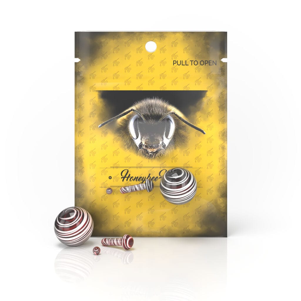 Front view of the Glass Mushroom Pillar Terp Set, showcasing a small, clear glass piece against a patterned gold background.