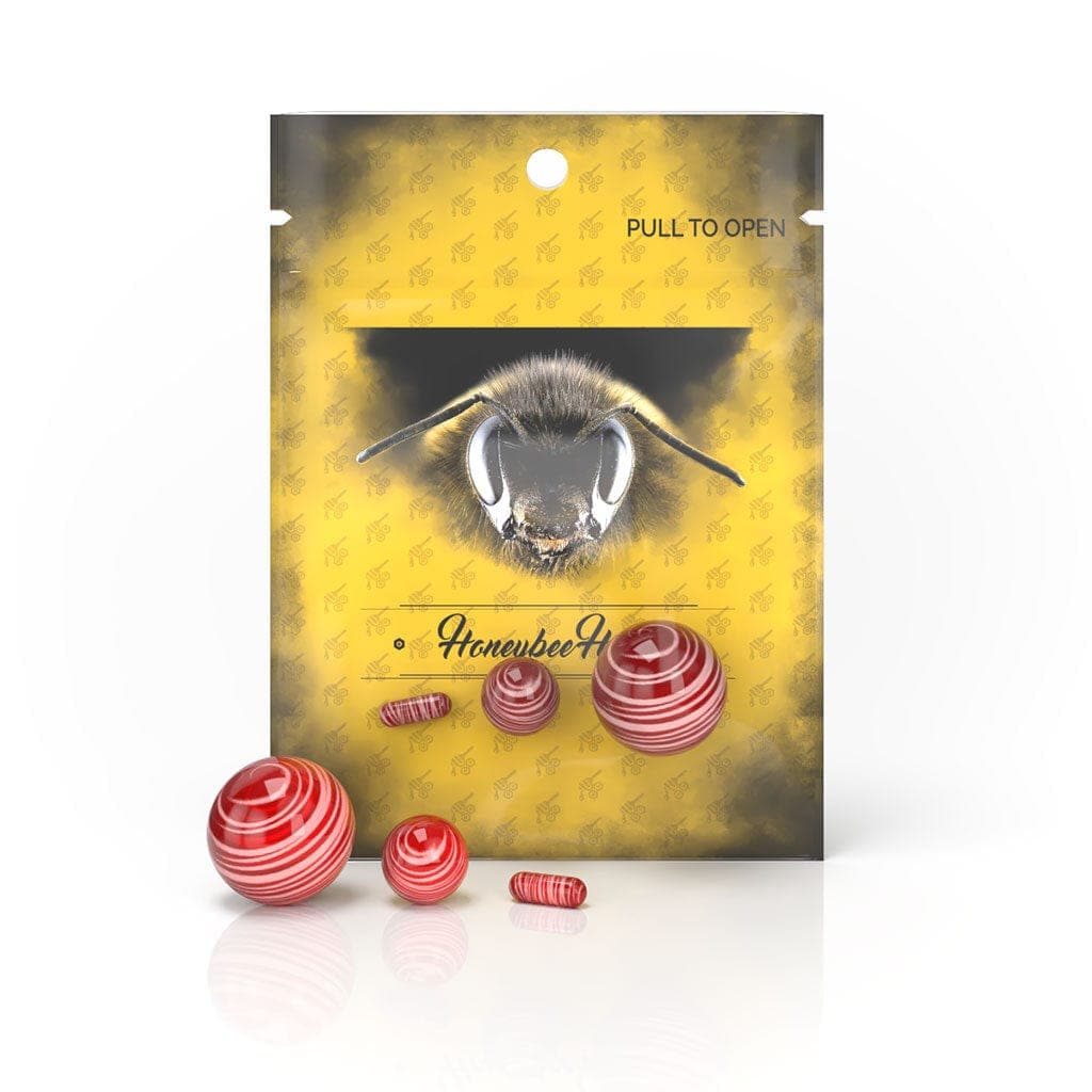 A top-down shot of the Honeybee Herb Dab Marble Set, displaying three colorful, rounded glass marbles against a neutral background.