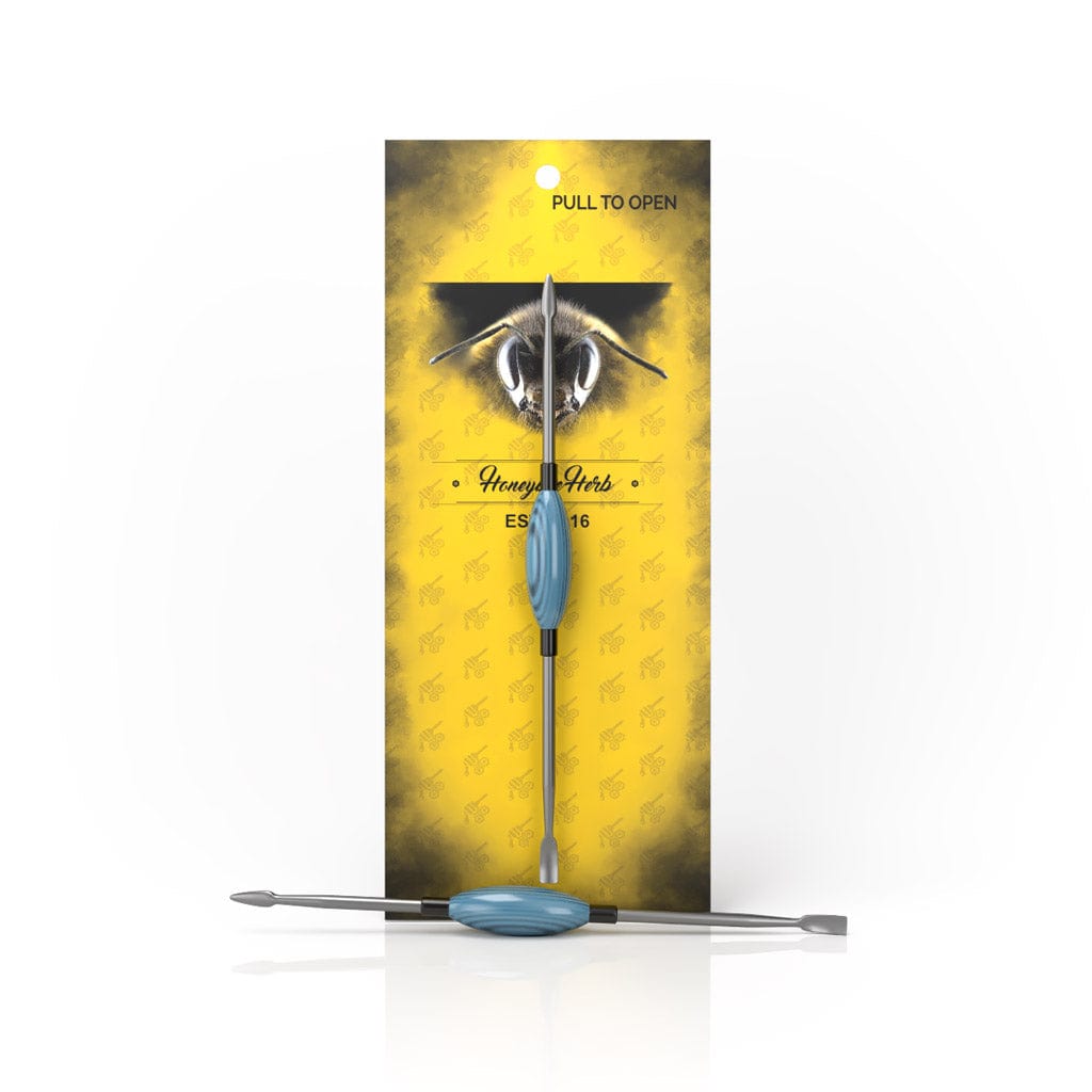 A close-up of the Oval Dab Tool, displaying its sleek, curved metal design against a neutral background.