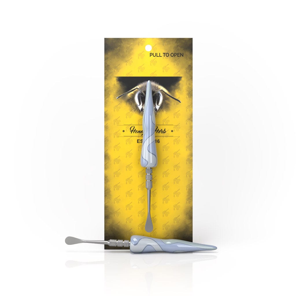 Front-facing image of the brown Swirl Tide Dab Tool showing a marbled handle on a metal shaft against yellow branded packaging.
