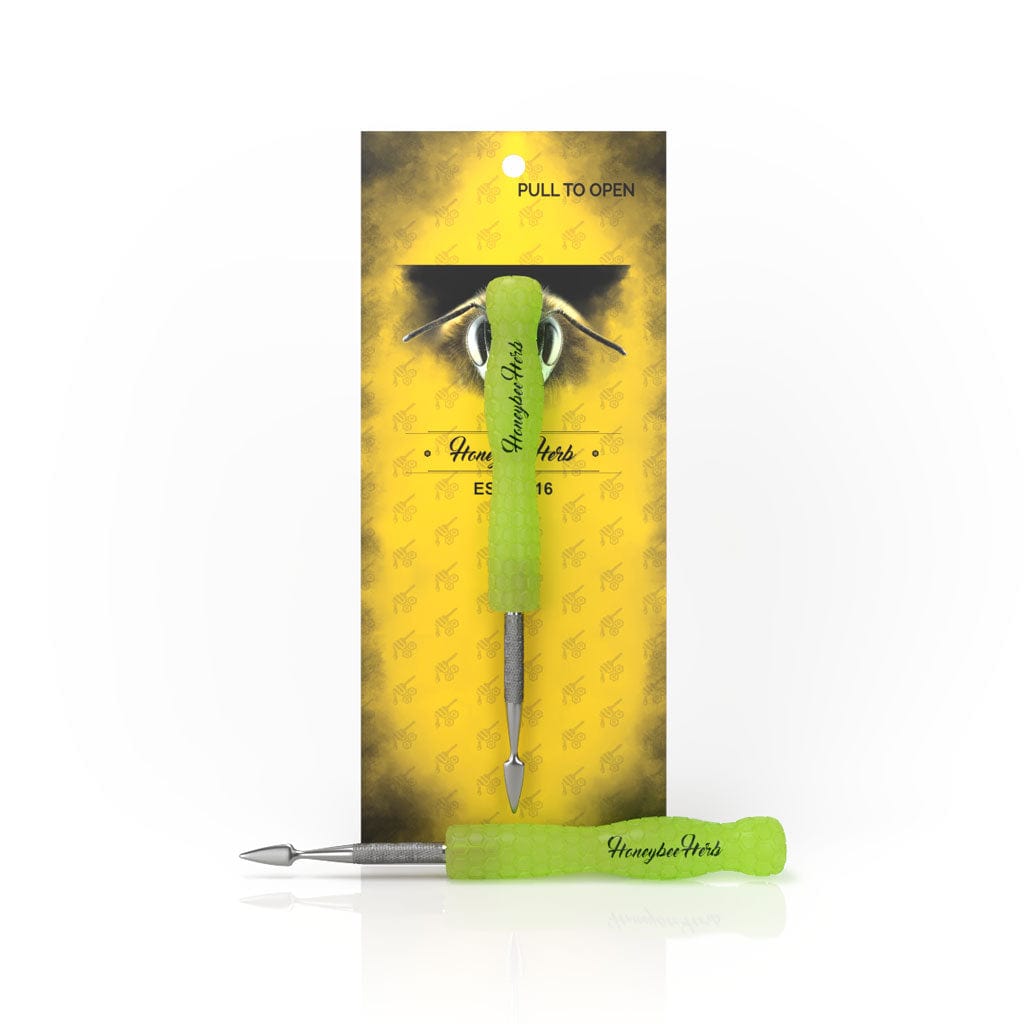 Centered front view of the Honeybee Herb Glow In The Dark Dab Tool showing a bright green textured handle with metal tips against yellow branded backing.