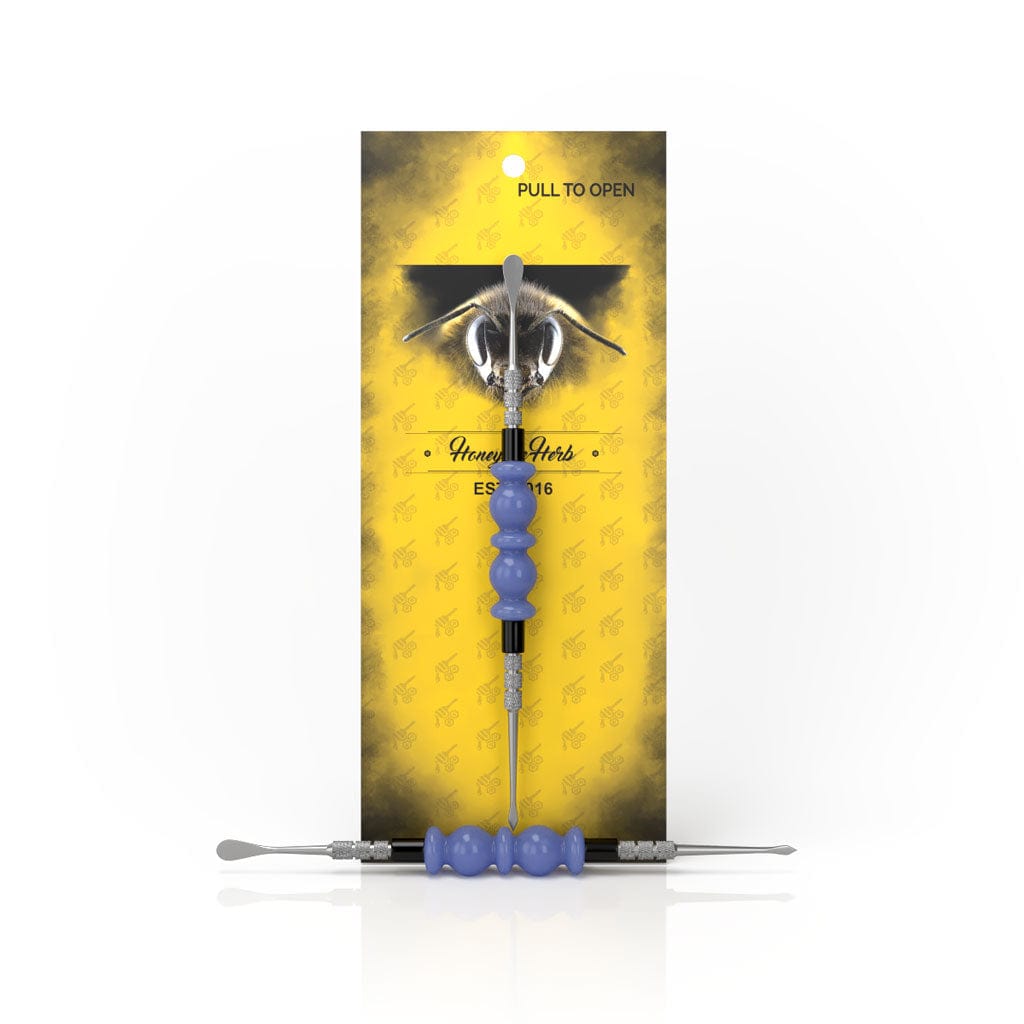 A close-up shot of the Bliss Dab Tool with a metallic tip against a yellow backdrop.