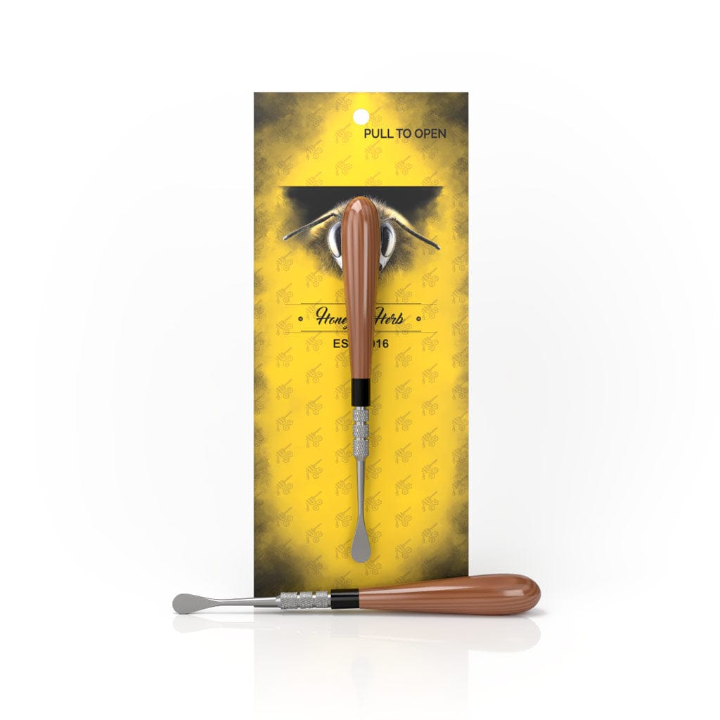 Front view of the Classic Dab Tool against a yellow background, displaying its metal tip and wooden handle.