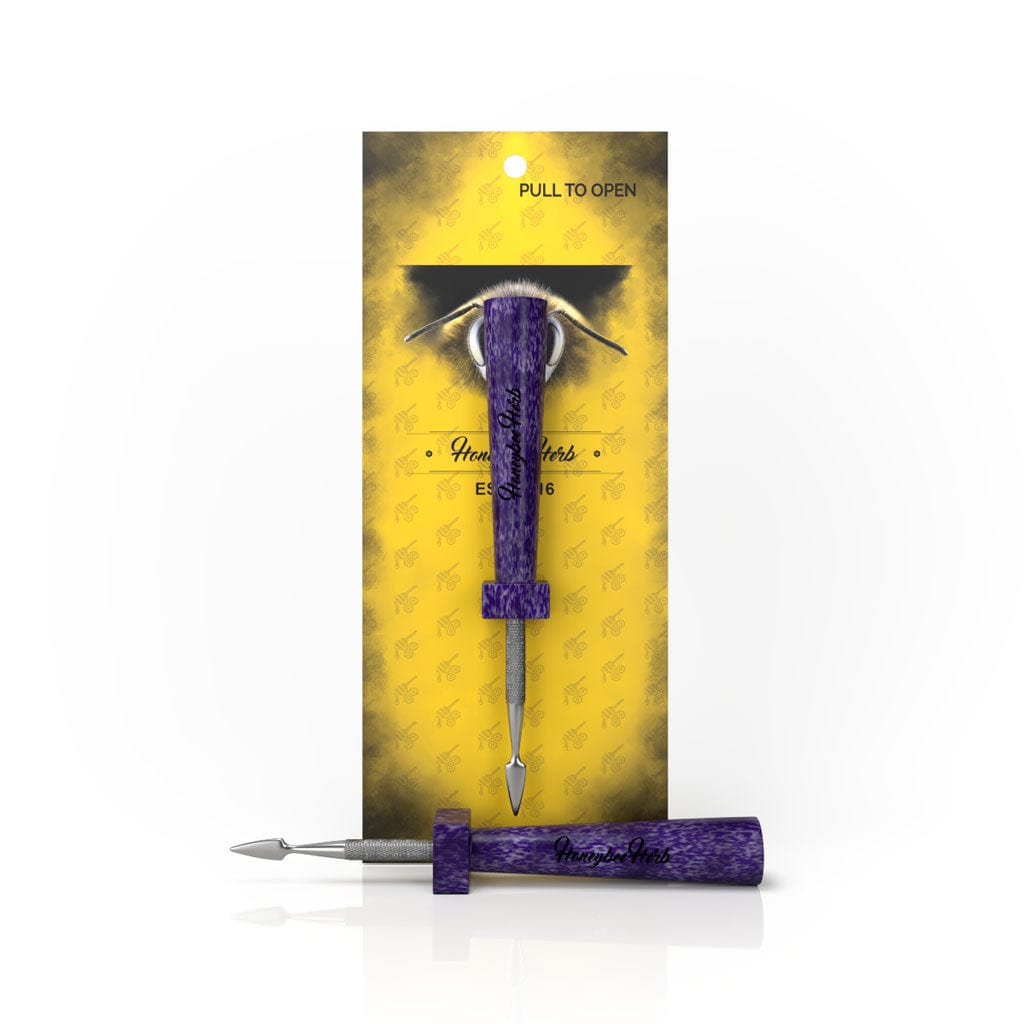 A close-up of the Classic Resin Dab Tool against a patterned yellow background, displaying its sleek, pointed tip.