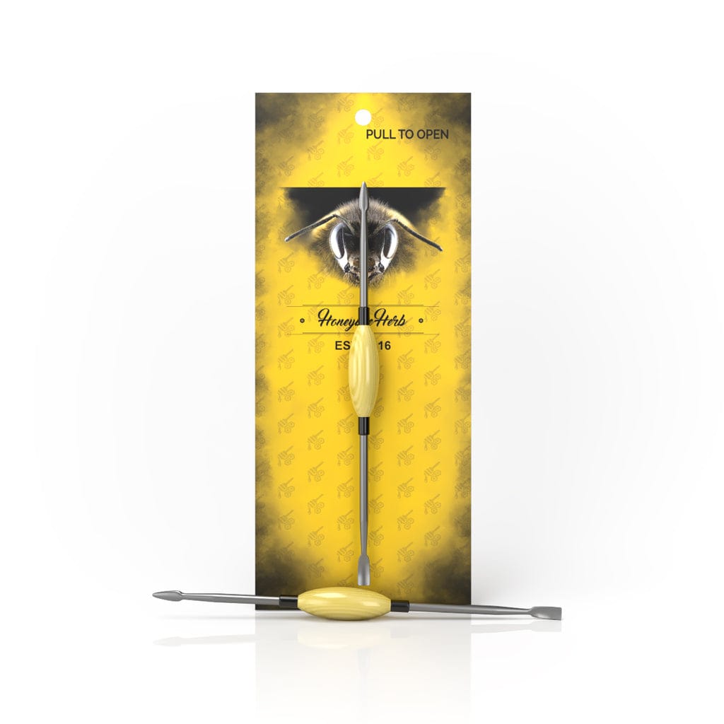 The Oval Dab Tool is pictured in a front view against a yellow backdrop, showcasing its sleek, metallic design.