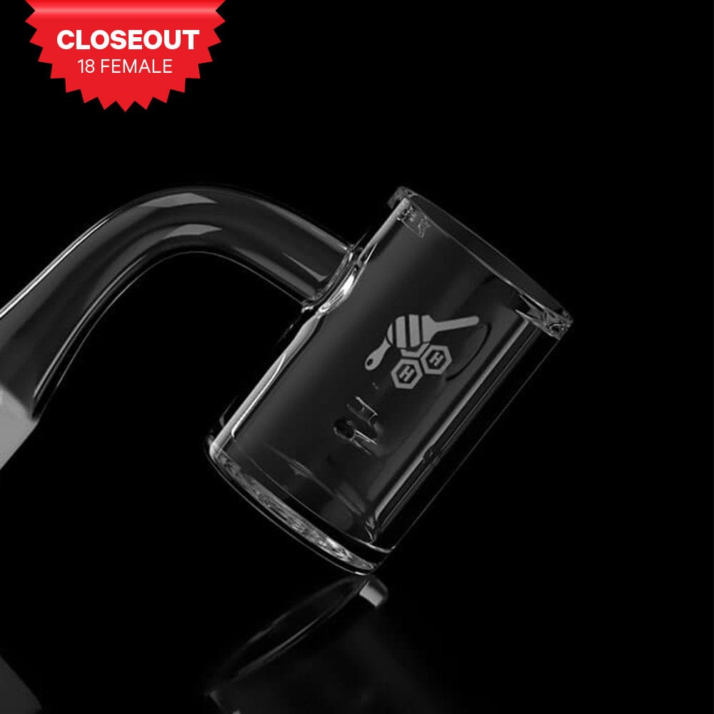 Angled close-up of the WHIRLWIND QUARTZ BANGER - 90Â° DEGREE | YL showing the clear glass joint and beaker-style cup with a honeycomb logo against a black background