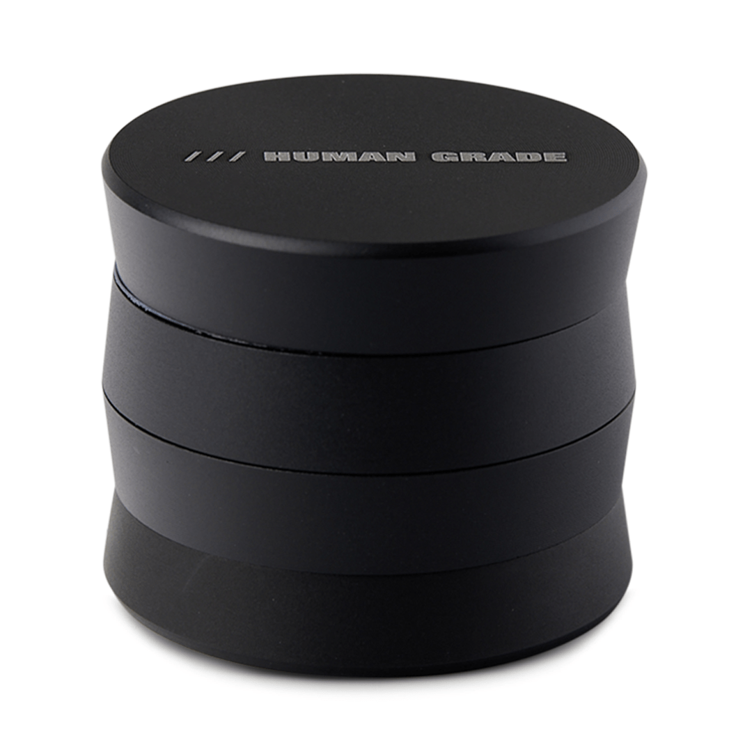 A close-up, angled view of the Human Grade Grinder 3A (2" 4-Piece) with a dark, metallic finish.