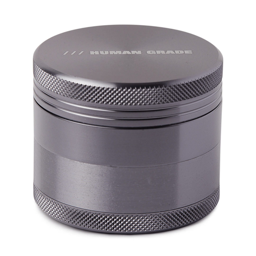 Close-up of the Human Grade Grinder 1A (2") with a textured, metallic finish and a four-piece construction.