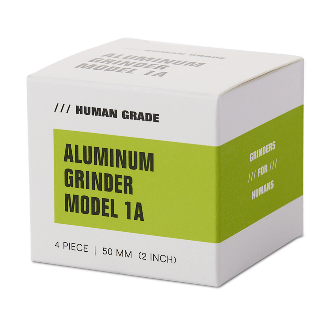 Front view of the Human Grade Grinder 1A (2" 4-Piece) displayed against a plain white background with text around the edge.