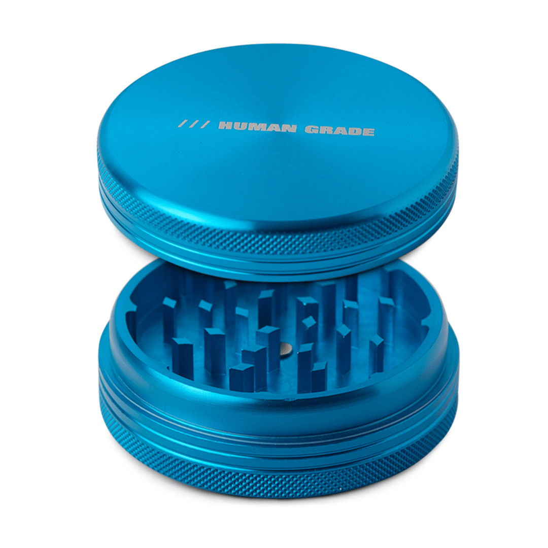 Front view of the Human Grade Grinder 1C (2.5" 2-Piece) featuring a textured metal exterior and circular design.