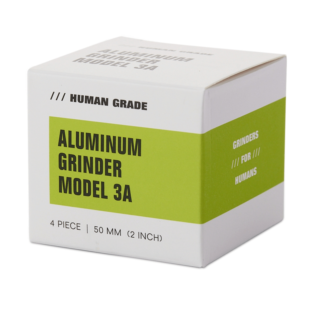 Front view of the Human Grade Grinder 3A (2" 4-Piece) with the brand name visible on the side, a sleek metal grinder.