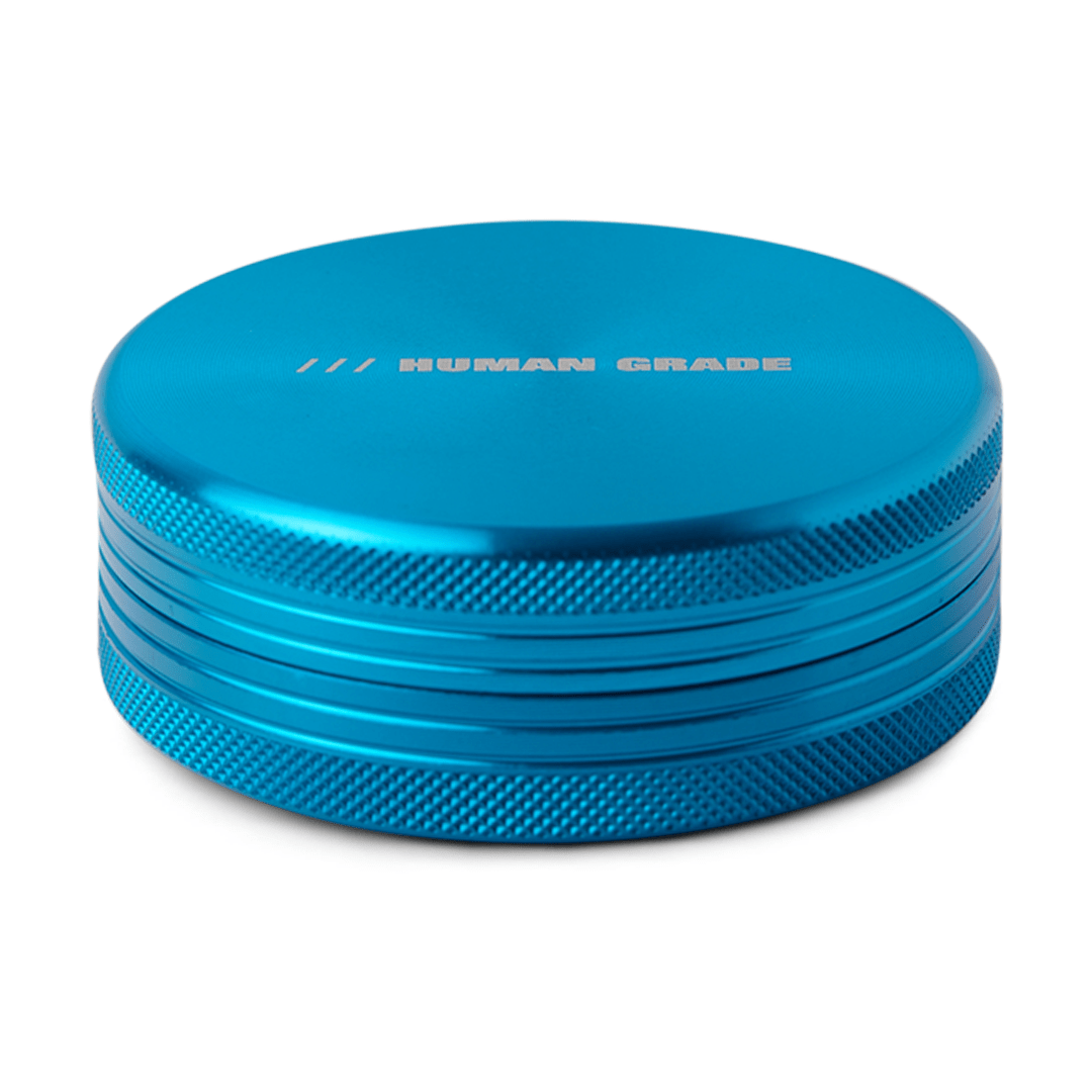 A close-up of the silver Human Grade Grinder 1C (2.5" 2-Piece) with a ribbed texture and a stacked, cylindrical shape.