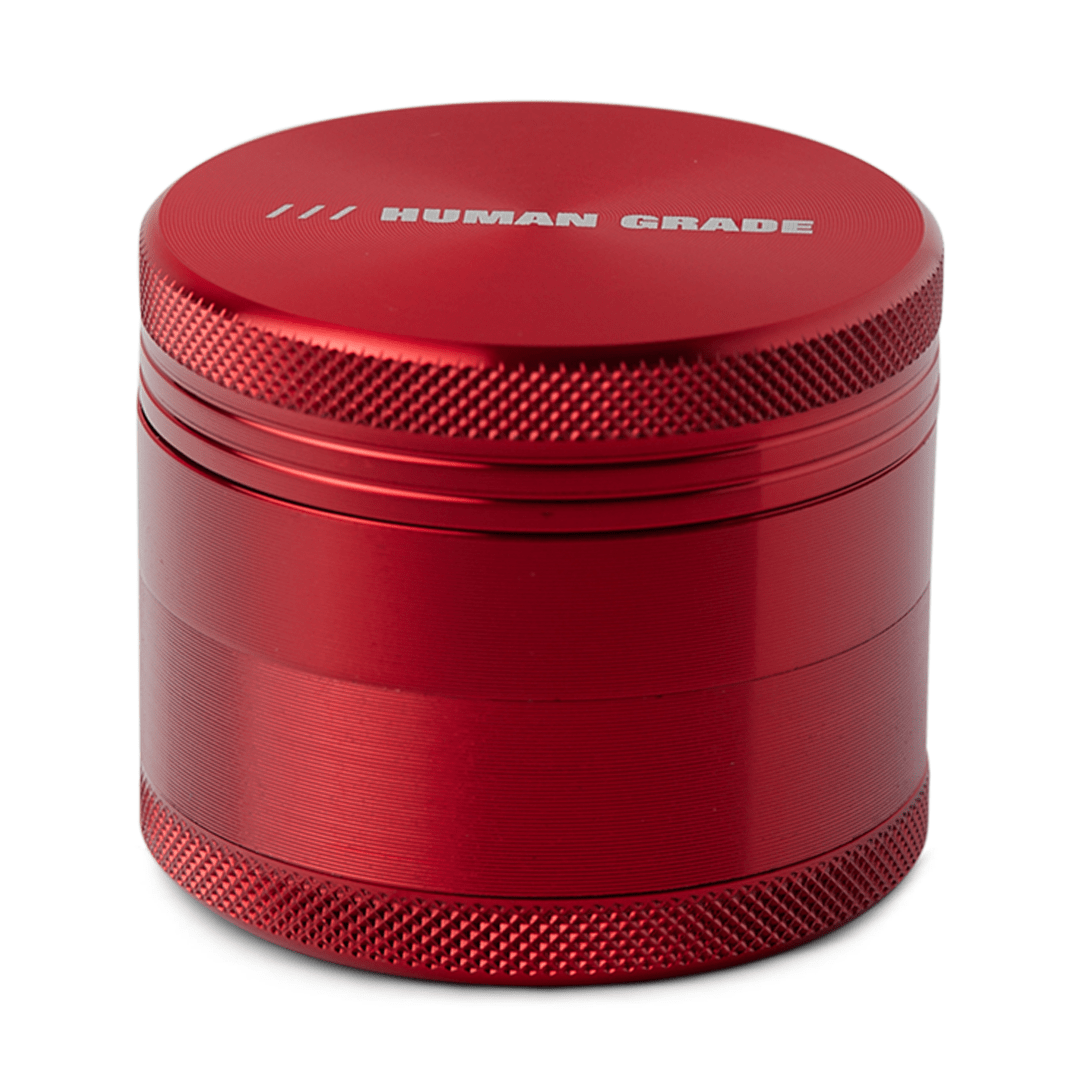 Front view of the Human Grade Grinder 1A (2") with a textured, metallic red finish, appearing as a compact, four-piece design.