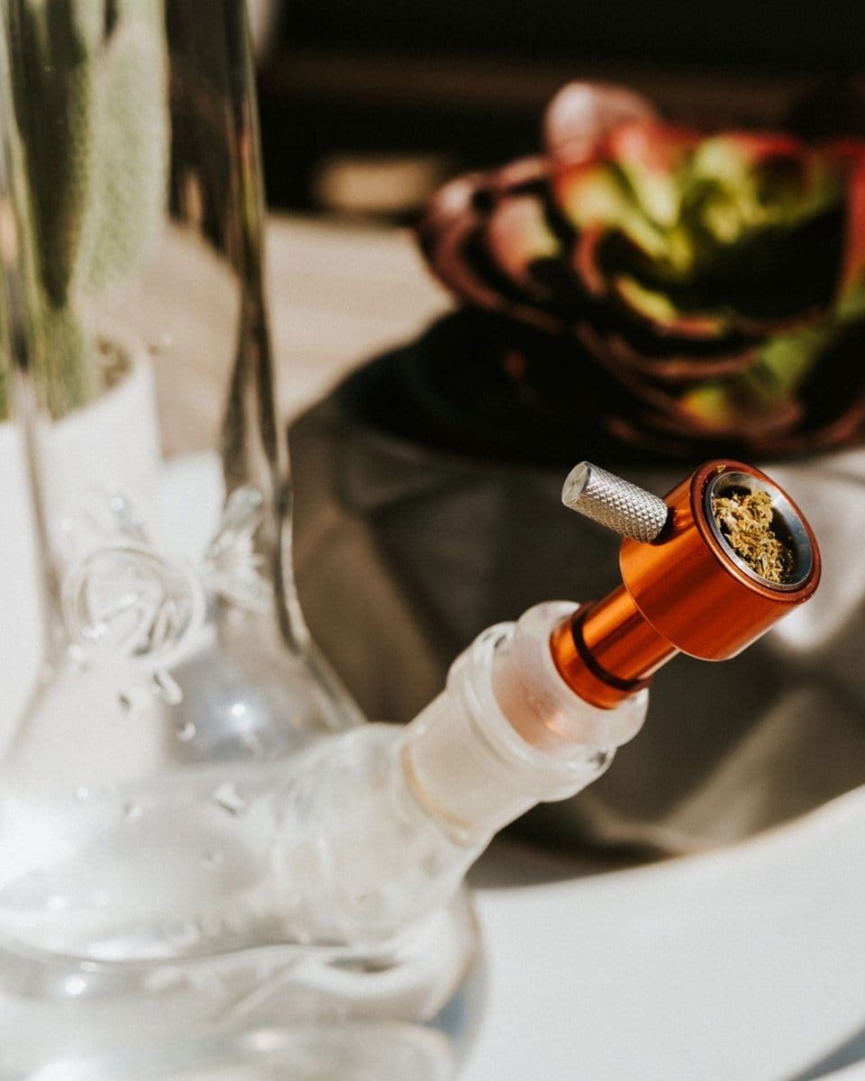 Close-up view of the joint on the Indestructible Bong Bowl, showcasing a dark-colored glass piece connected to a clear glass tube.