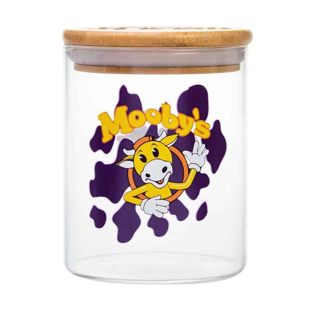 Front view of the Mooby's Stash Jar, a clear glass jar featuring a cartoon cow design with a wooden lid.