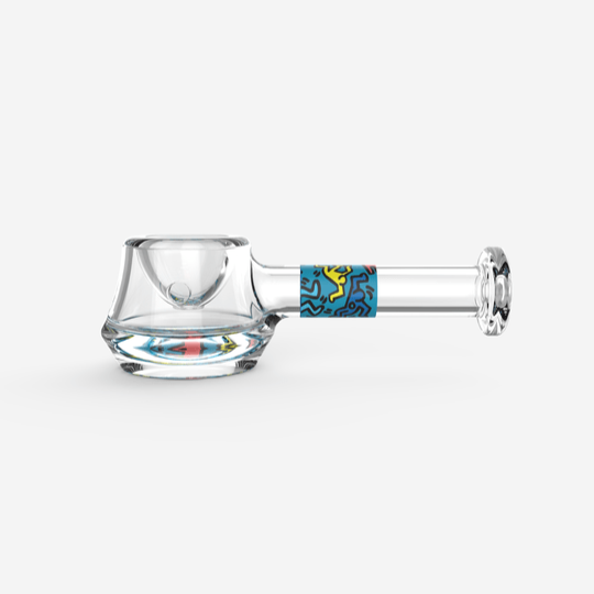 A side view of the K.Haring Spoon Pipe, crafted from clear glass with a uniquely curved design.