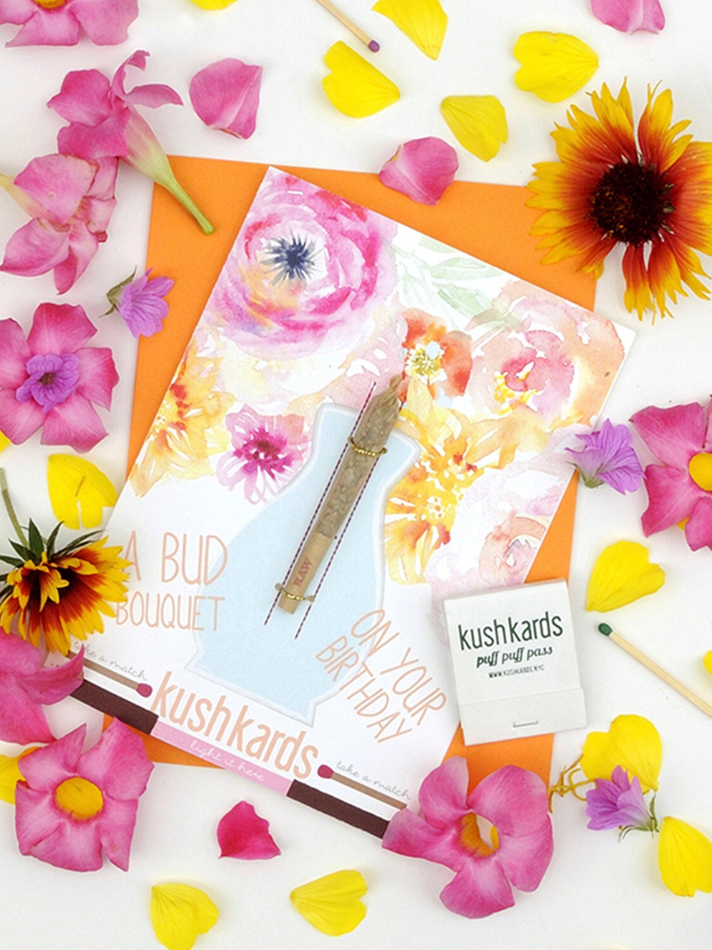 An overhead shot displays the Bud Bouquet Birthday Card surrounded by colorful flowers, creating a bright and festive arrangement.