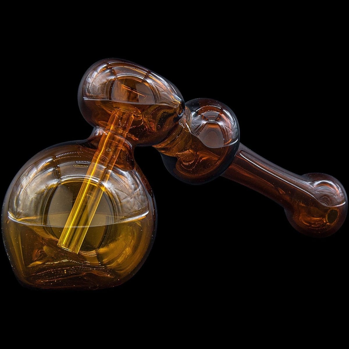 A three-quarter view of the “Glass Hammer” Glass Hammer Bubbler Pipe, showcasing the amber-colored glass and curved design.