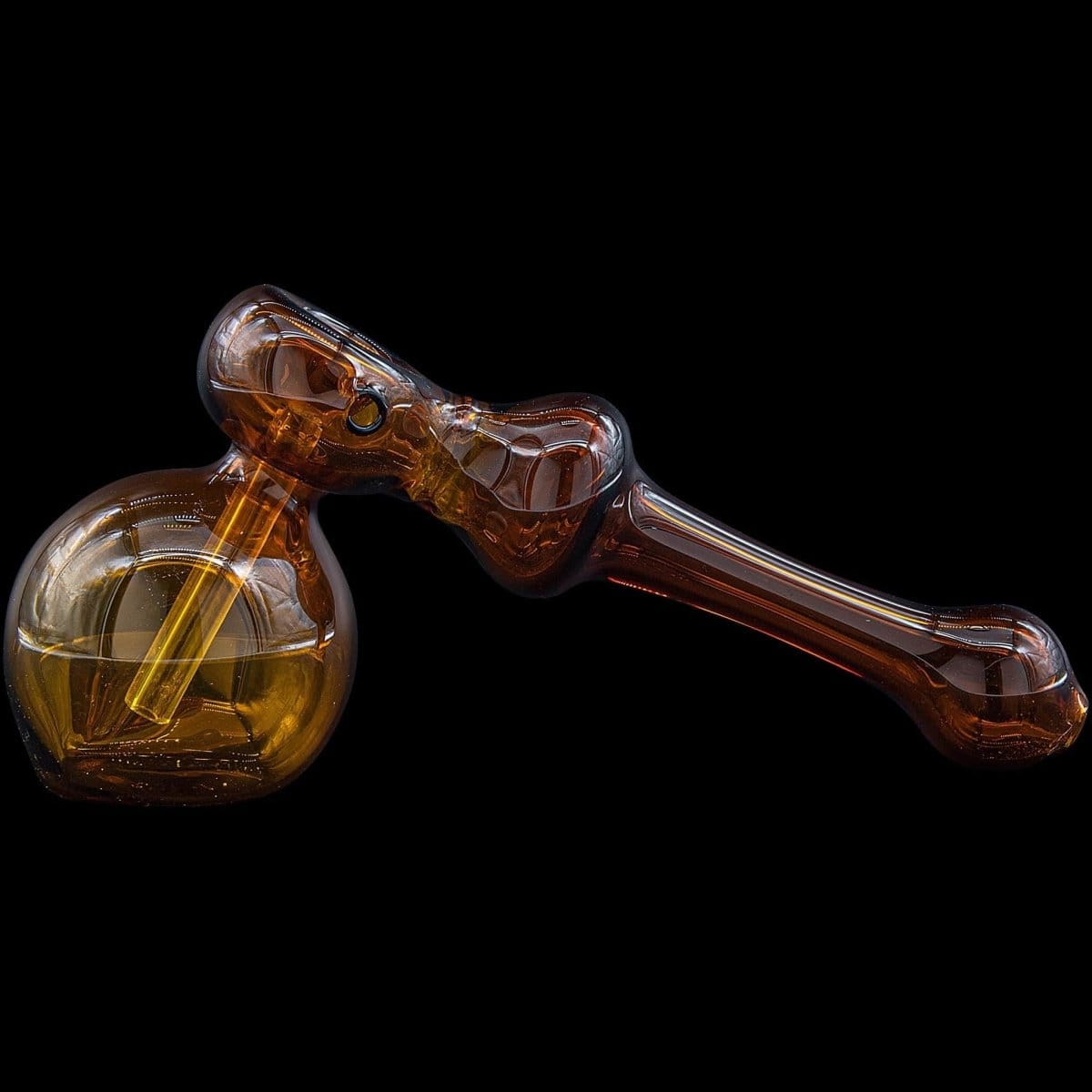 A studio shot of the “Glass Hammer” Glass Hammer Bubbler Pipe, showing its amber-colored glass and curved design from a slightly elevated angle.