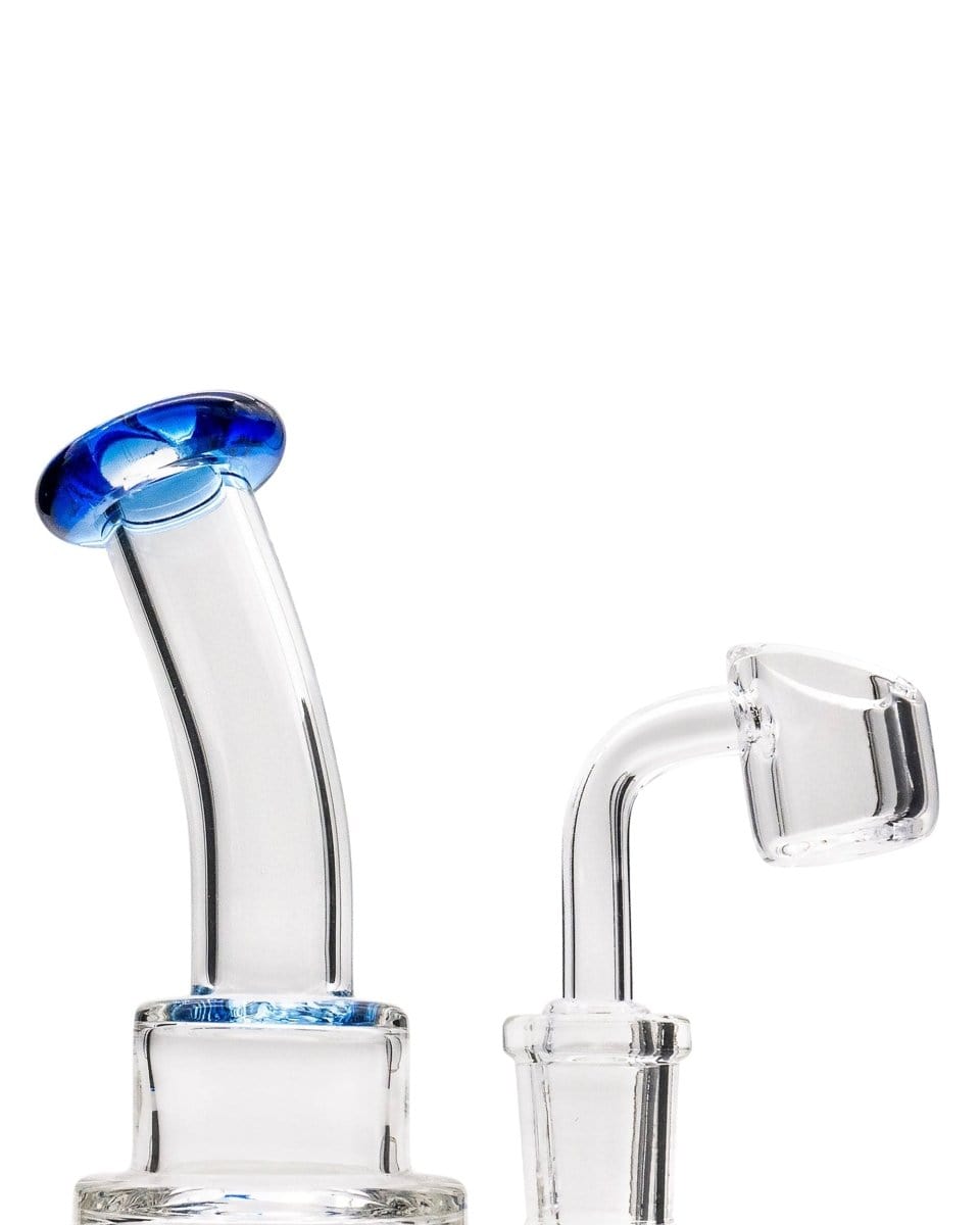 A close-up, angled view of the Layer Cake Color Accented Dab Rig, showcasing its clear glass construction and simple design.