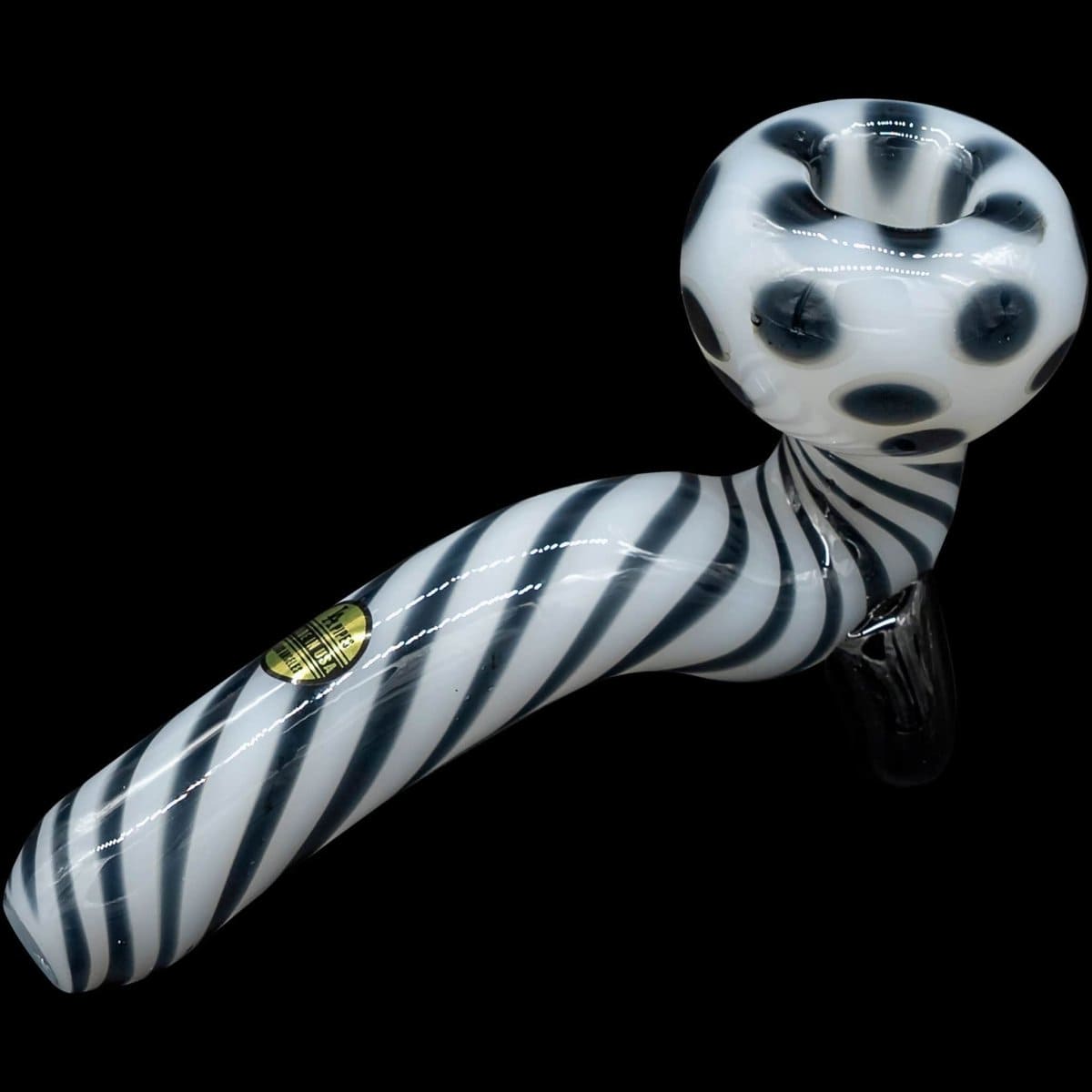 A side view of the "Ivory Locks" Bone White Sitting Sherlock Glass Pipe, resting on a black surface with a curved bowl.