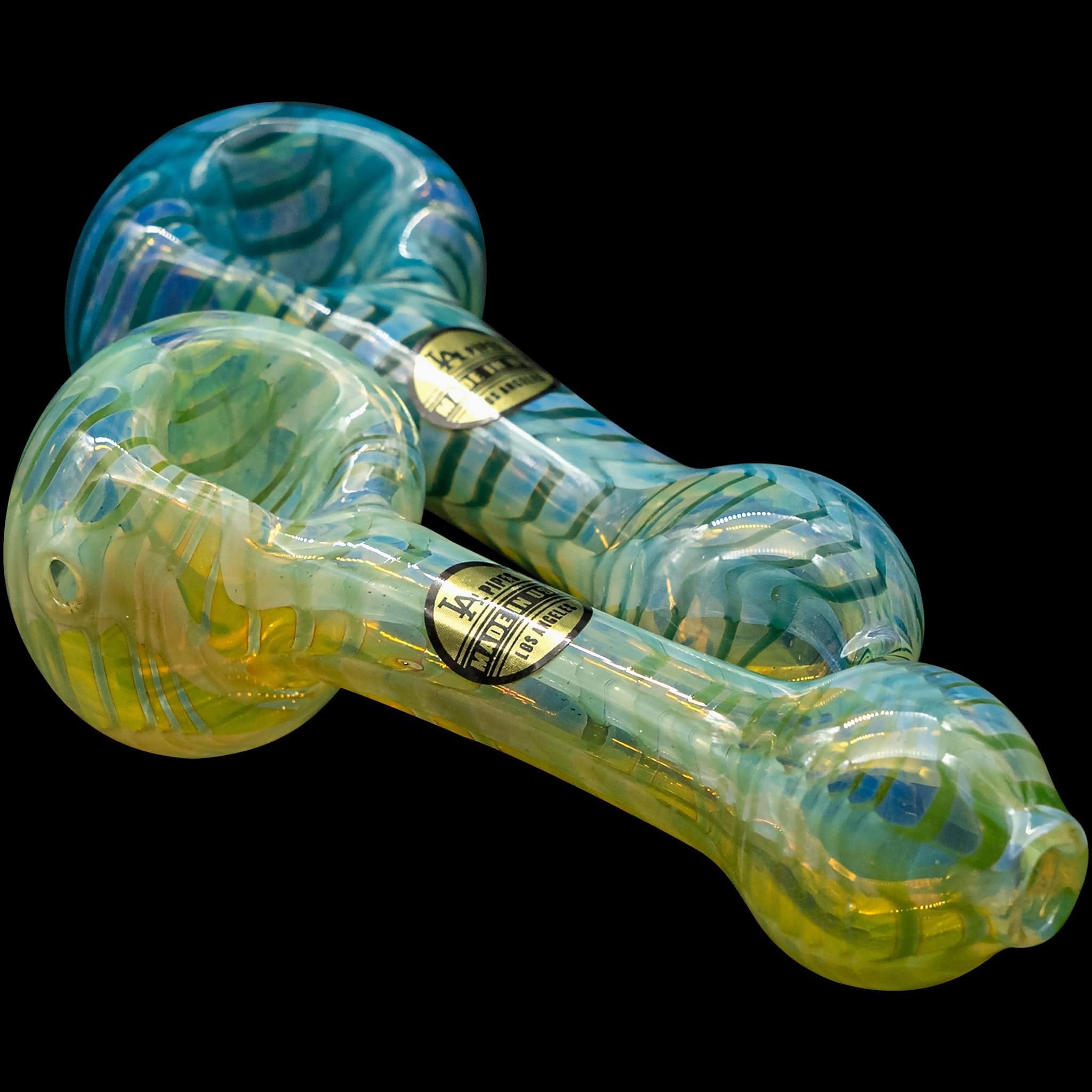 A detailed side view of the “Raker” Glass Spoon Pipe, displaying its vibrant blue and green glass swirls.