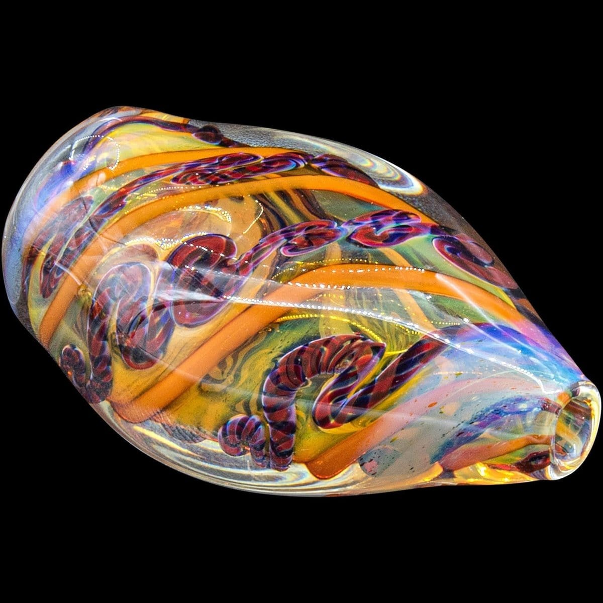 A detailed close-up of the “Skipping Stone” Inside-Out Chillum, showing the transparent glass with interior color swirls against a dark background.