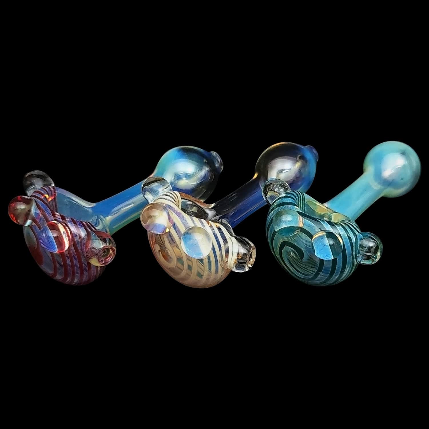 A side view of the “Spiral Marble Head” Glass Spoon Pipe, showing a colorful, marbled glass head and curved body against a dark background.