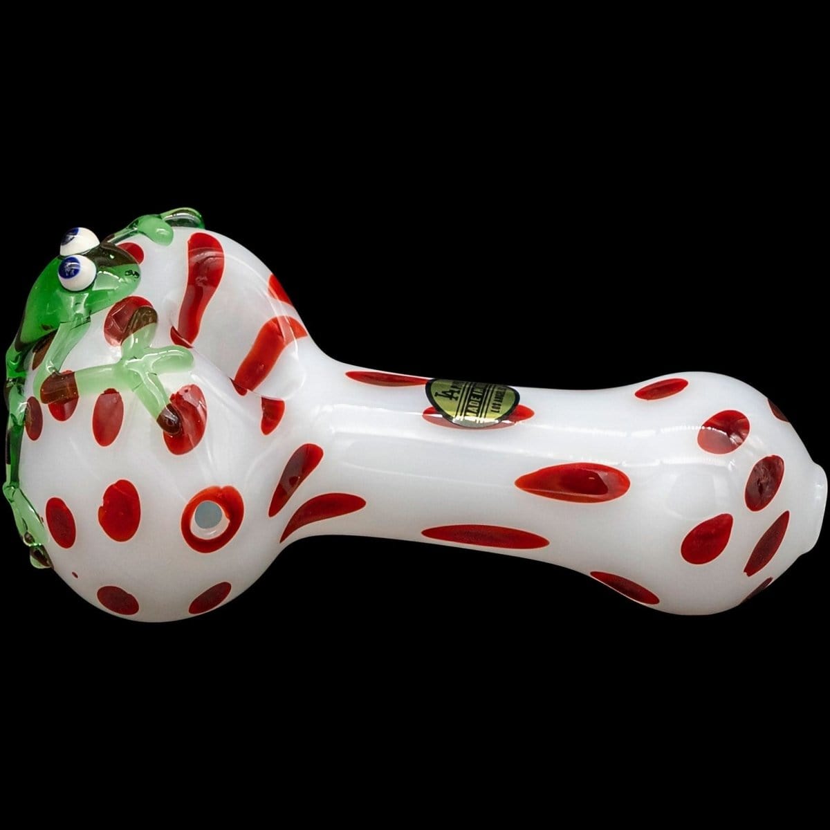 A studio shot of the “Spotted Poison Frog” Spoon Glass Pipe, showcasing its colorful, patterned design against a black background.