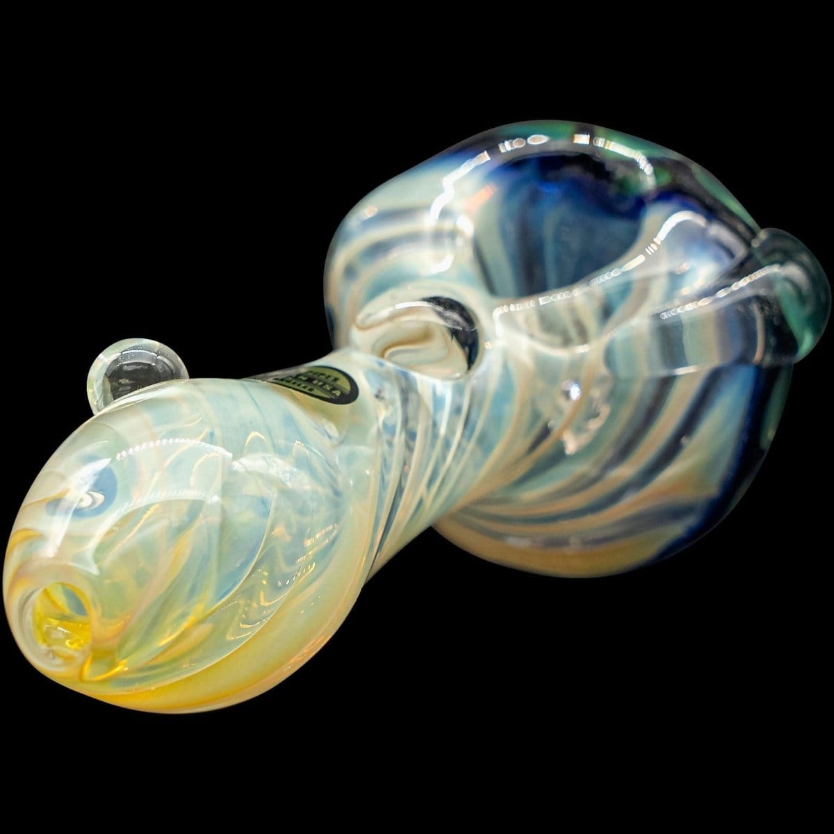 A side view of “The Hive” Honeycomb Color Changing Glass Pipe shows a curved, multi-toned glass piece against a dark background.