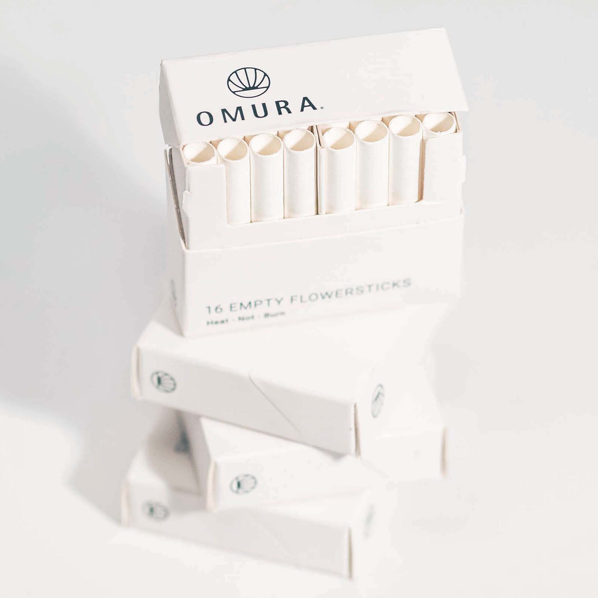 Front view of Omura Flowersticks, stacked and packaged, with a clean white design and branded logo.