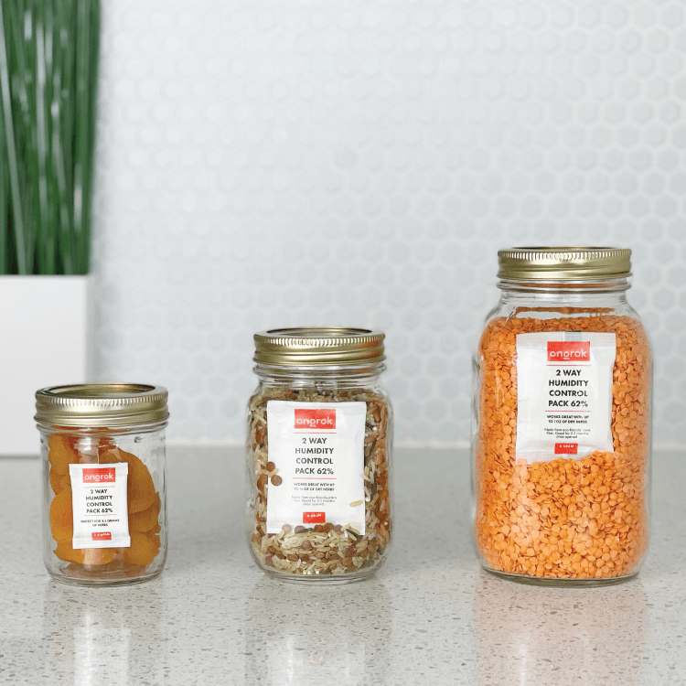 A bright, eye-level shot of 2-Way 62% Humidity Packs in varying sizes, arranged against a white, speckled countertop.