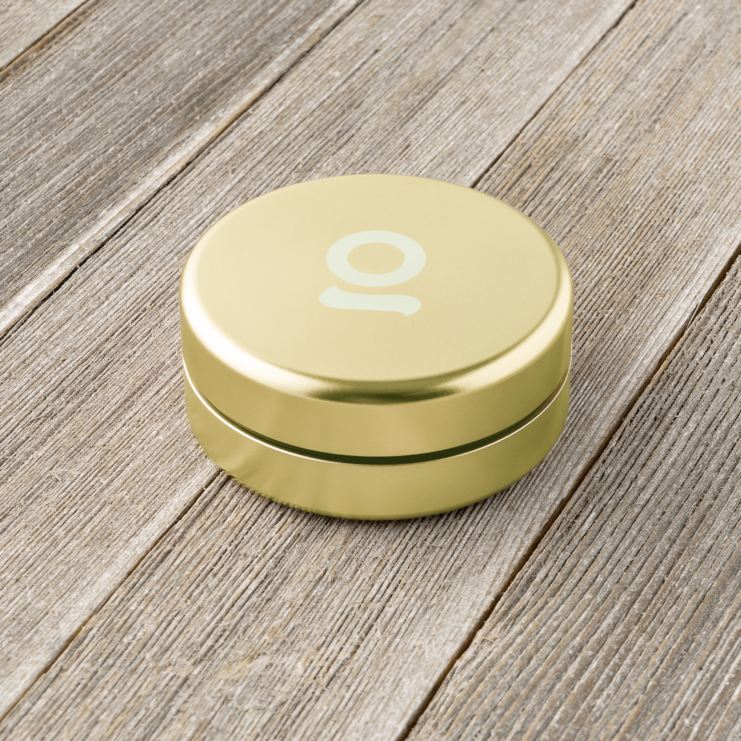 Close-up of the Aluminium Storage Puck sitting on a textured wooden surface in a soft, diffused light.