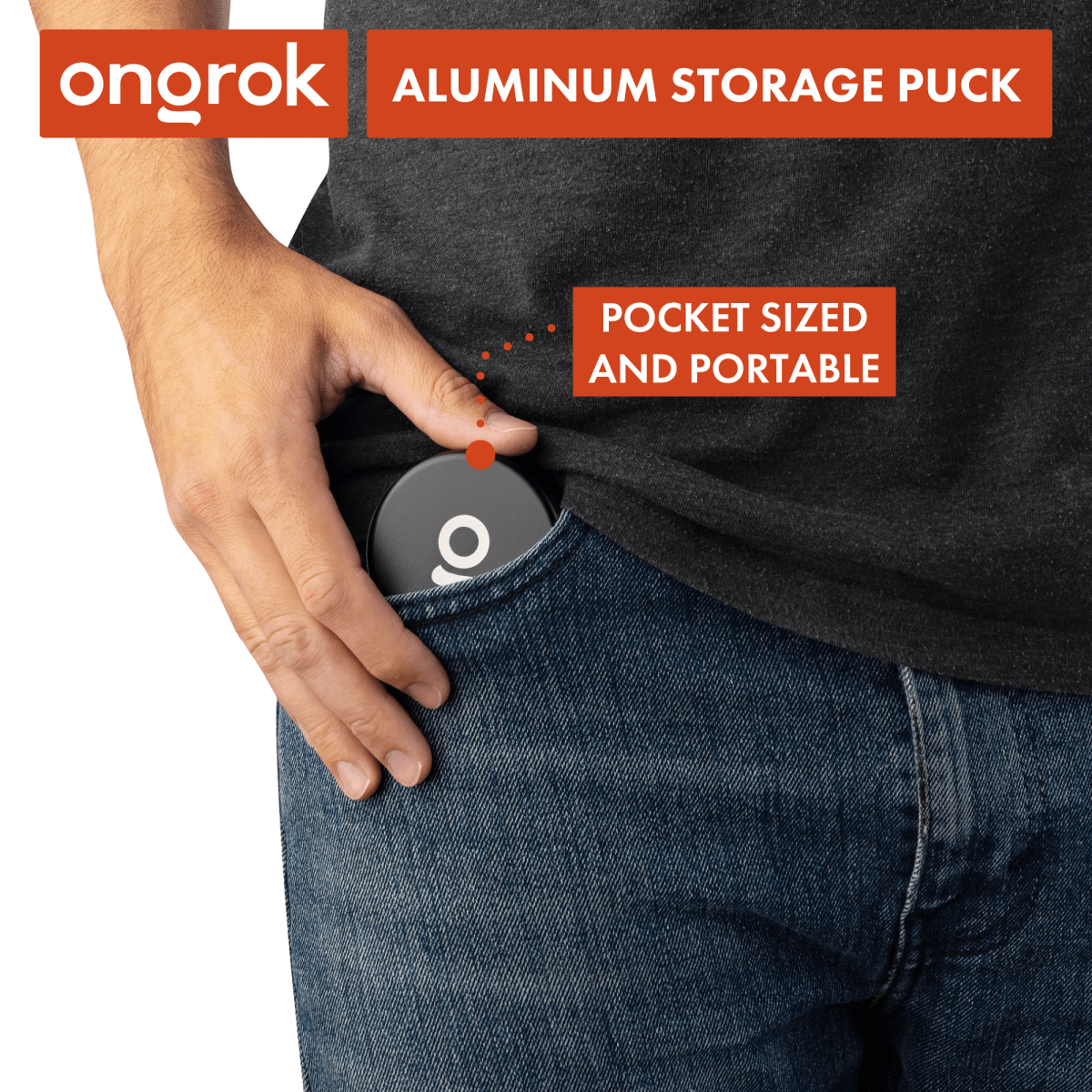 A hand holds the silver Aluminium Storage Puck against a dark denim background, showing its circular design.