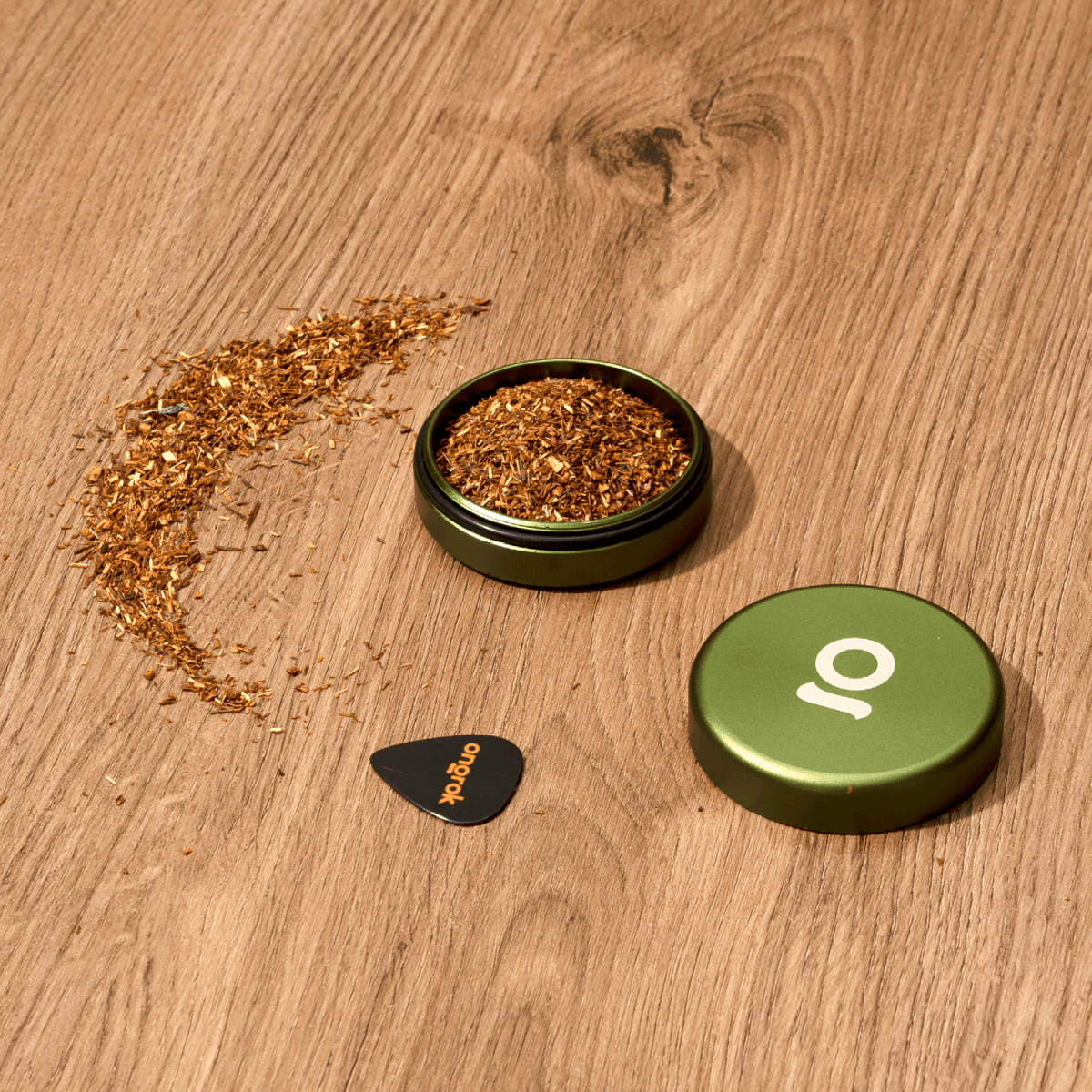 An Aluminium Storage Puck sits open on a wooden surface, revealing its contents and a simple, cylindrical design.