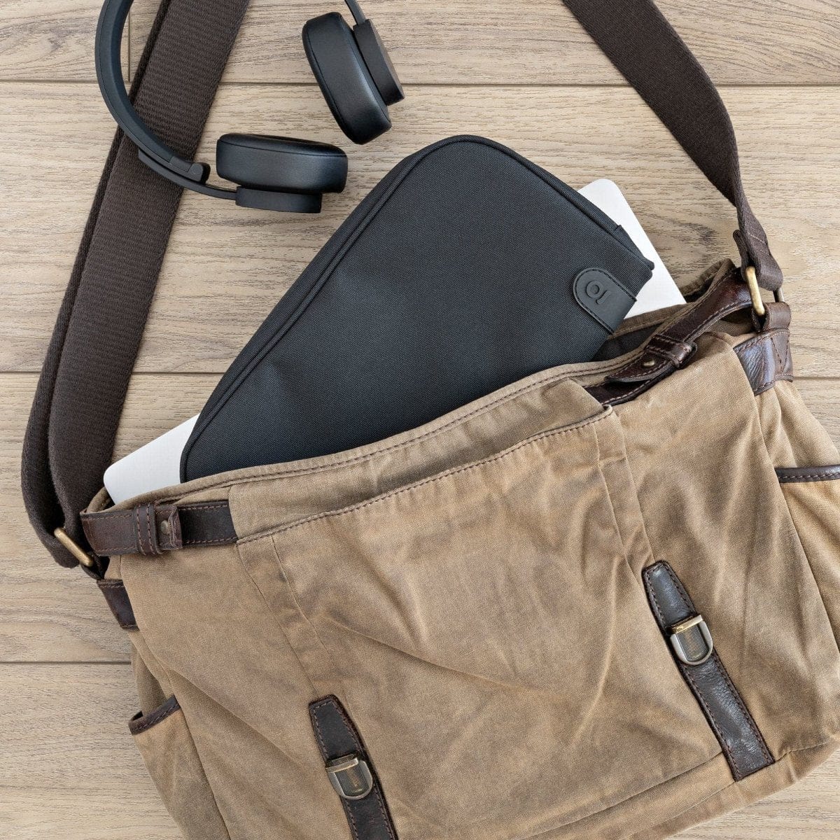 A slightly angled view shows the Carbon-lined Wallets with Combination Lock V 2.0 peeking out of a tan canvas bag.