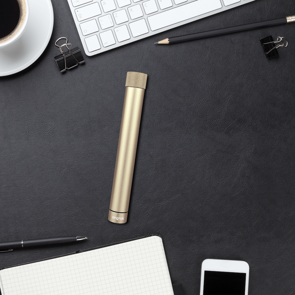 A sleek, cylindrical Premium Storage Tube  Single rests among office supplies on a dark desk in a top-down view.