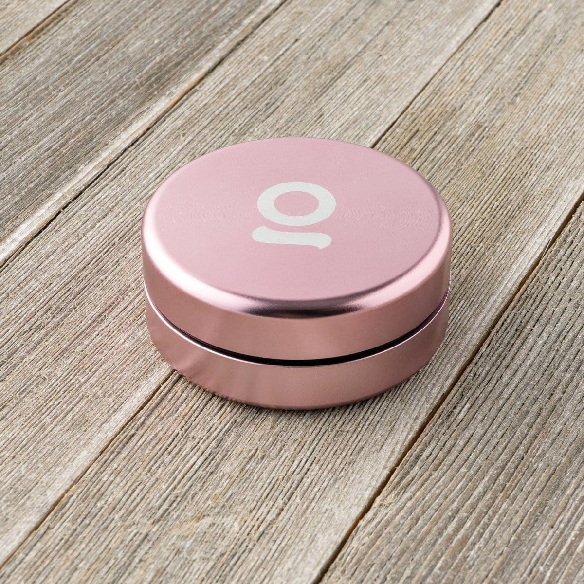 A close-up, top-down view of the Aluminium Storage Puck on a textured wooden surface, highlighting its circular shape.