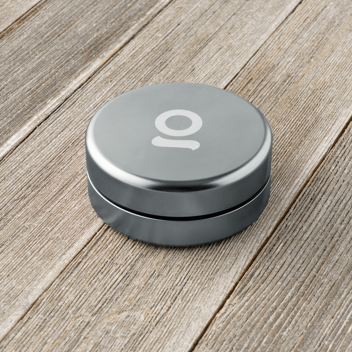 A low-angle studio shot of the Aluminium Storage Puck, showcasing its sleek, circular design and metallic finish.