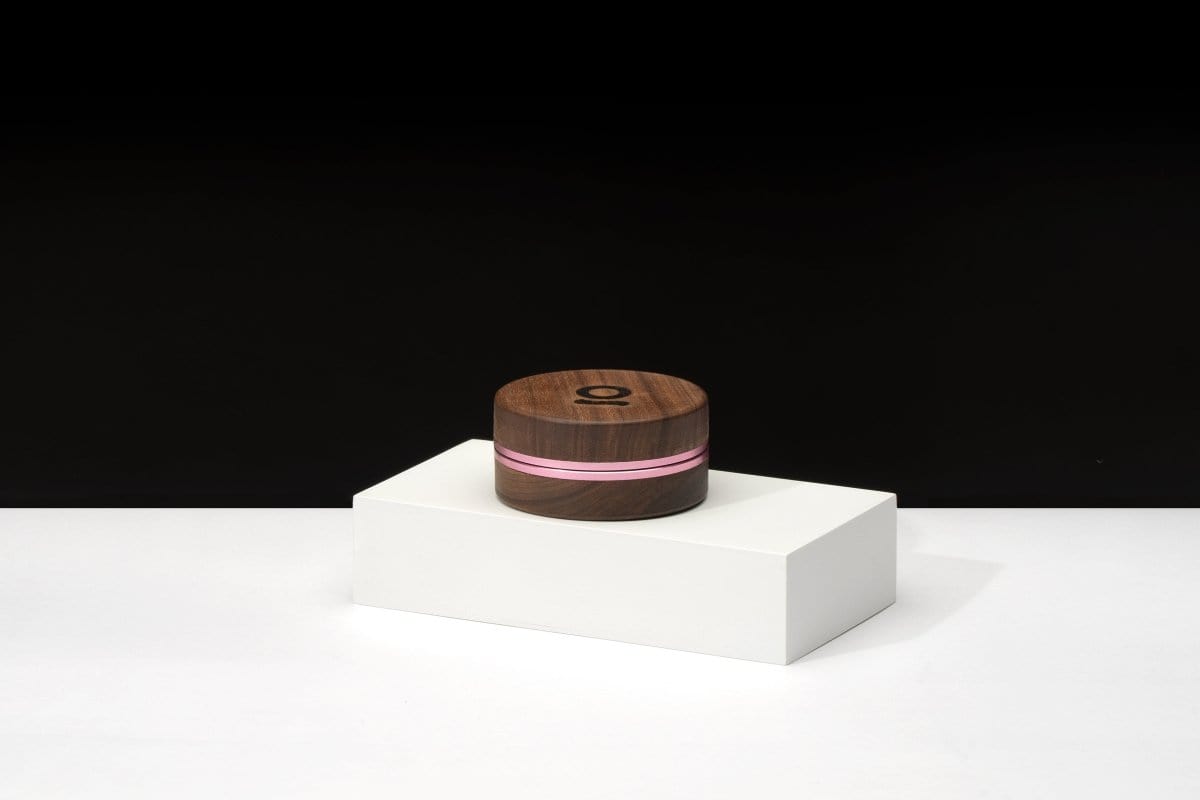A centered, top-down view of the 3 Inch, 2-Piece Walnut Grinder on a white platform, highlighting its dark wood finish.