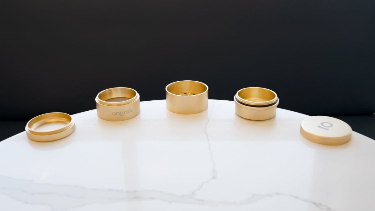 A top-down view of the 5 Piece Storage Grinder, showcasing the five golden containers arranged on a light-colored surface.